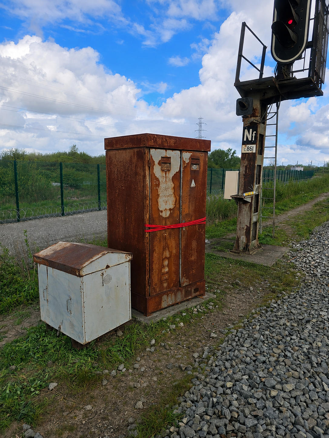 Heavily corroded signalling cabinet strapped shut beside signal c861